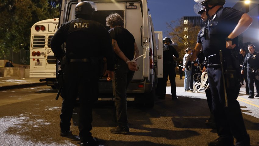LOS ANGELES, CA – JUNE 11, 2025:  Police officers arrest protesters and load them on to vehicles to enforce a curfew downtown Wednesday, June 11, 2025 in Los Angeles, California. (Jason Armond / Los Angeles Times via Getty Images)